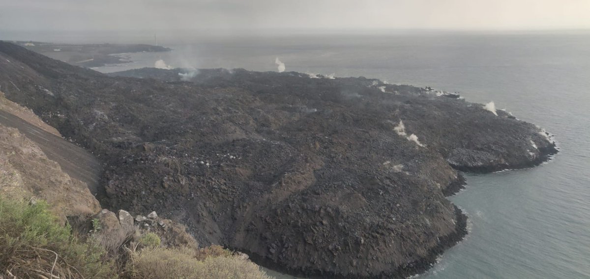 A smoking lava flow sticking out into the ocean